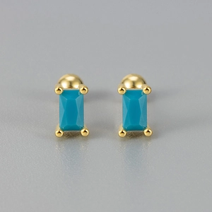 Macro detail of gold geometric screw stud earrings with emerald-cut turquoise stone