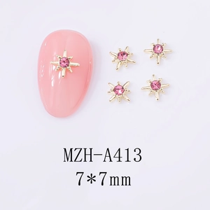 Detailed 7x7mm gold star nail art charms with pink zircon on manicured nails