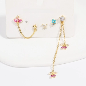 Detailed set of gold earrings with floral and butterfly zircon pendants on white card