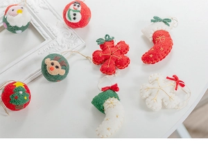 Detailed view of handmade Christmas wool felt ornaments including Santa, elk, and snowflakes
