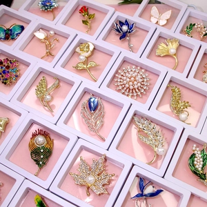 Detailed collection of floral and butterfly brooches with enamel and pearls in a box