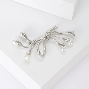 Vue détaillée d'une broche nœud en argent avec 5 perles élégantes et cristaux brillants
