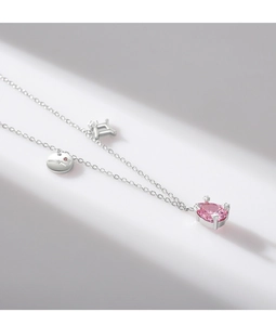 Detail of silver S925 necklace with pear-shaped pink stone and bow charm