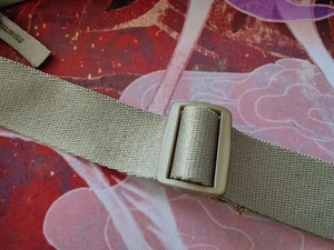 Detail of adjustable khaki nylon strap and plastic buckle for lightweight crossbody bag