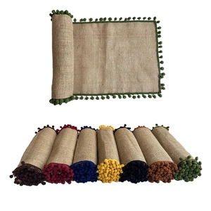 Natural jute table runner with colorful pom-poms shown in multiple vibrant colors