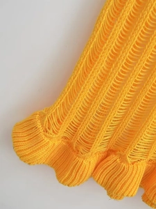 Detailaufnahme von gelbem Strickgewebe mit Durchbruchmuster und Rippenbündchen