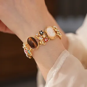 Vintage gold-tone enamel flower bracelet featuring cameo portrait and cat eye stone