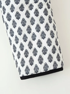 Close-up of quilted floral print cotton fabric with contrast black bound edge trim