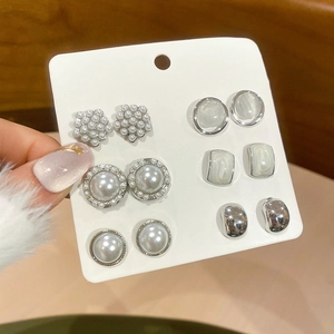 Detailed view of six pairs of elegant pearl and zircon stud earrings for women