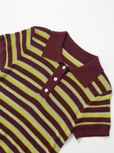 Detailed macro shot of striped knit polo shirt texture with white button closure