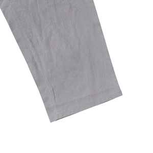 Detailed macro shot of grey linen pants hem with premium double stitching craftsmanship