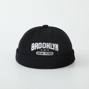 Close-up of black corduroy docker cap with white Brooklyn New York star embroidery