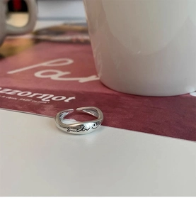 Close-up of S925 silver open ring with smile engraving on a lifestyle background