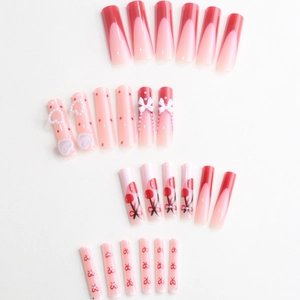 French tip press-on nails with cherry patterns, 3D heart charms and pink lace designs
