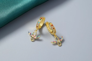 Détail de boucles d'oreilles infini en or 18K avec des pierres zircones colorées