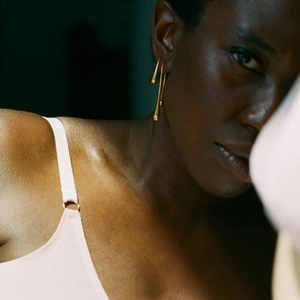 Close-up of elegant gold water drop earrings with multi-strand fringe on a model