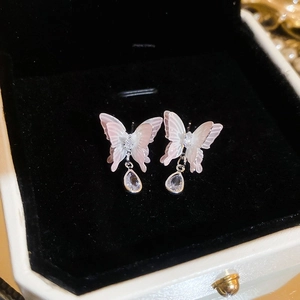 Vue macro de boucles d'oreilles papillon dégradé avec gouttes de cristal en boîte