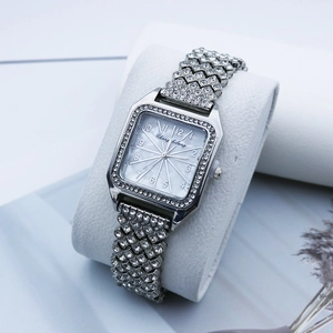 Vue macro d'une montre carrée argentée de luxe ornée de strass et d'un cadran en cristal