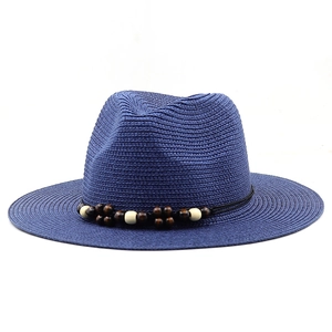 Detail of blue-purple woven Panama hat with wooden beads and black string decoration