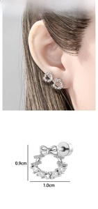 Macro detail of silver bow wreath cartilage stud with zircon inlay and star pendant