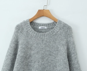 Close-up of grey knit sweater showing soft fluffy texture and ribbed crew neck detail