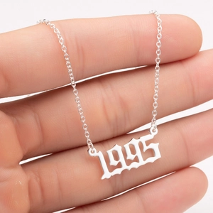 Detail of silver stainless steel necklace with 1995 gothic year number pendant