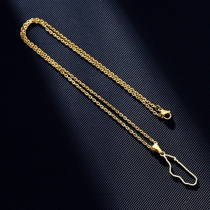 Detailed close-up of a golden Madagascar map pendant necklace on a black textured surface