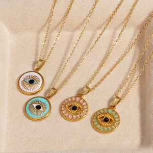 Detail view of four colorful Evil Eye necklaces in gold titanium steel on beige tray