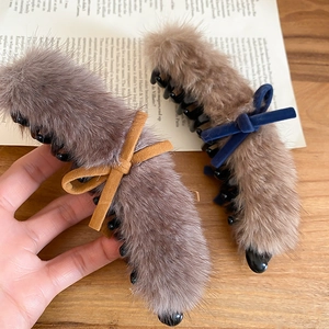 Detailed close-up of plush faux fur hair claw clips with velvet and suede bow accents