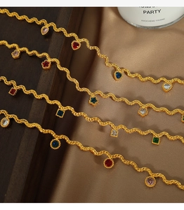 Detailed macro of golden wave chains featuring colorful zircon charms in various shapes