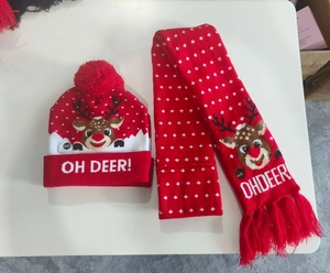 Detail of red Christmas knitted hat and scarf set with LED lights and elk patterns