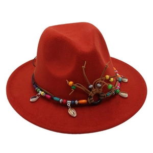 Close-up of deep red fedora hat with ethnic beads and seashell decorative band