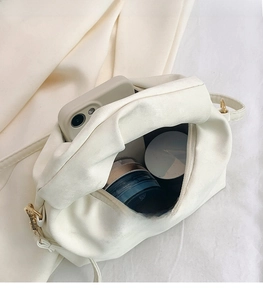 Detail view of the spacious inner compartment showing makeup and phone storage capacity