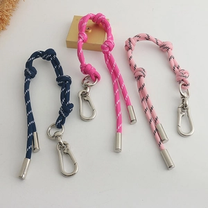 Detailopname van kleurrijke gevlochten koordbanden in navy, magenta en roze met metalen clips