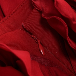 Macro de la fermeture éclair invisible rouge et du satin côtelé sur la robe bustier