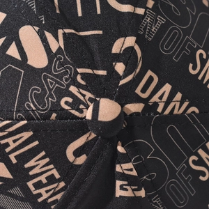 Close-up of black cotton baseball cap showing graffiti print and twill fabric texture