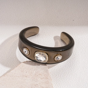 Detail of vintage brown resin bangle featuring sparkling crystal clusters on a stone surface