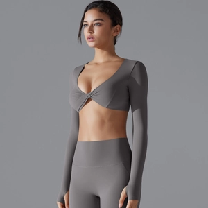 Dettaglio top yoga grigio a maniche lunghe con nodo frontale in tessuto elastico