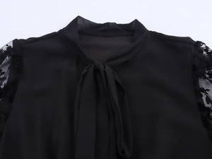 Dettaglio della manica in pizzo francese ed elegante scollatura con fiocco in nero