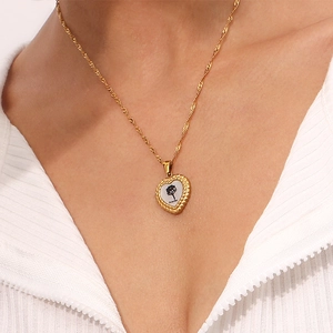 Vue détaillée du pendentif cœur plaqué or 18K avec gravure October et motif d'arbre