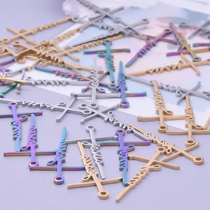 Macro view of assorted 18k gold and silver Jesus cross charms on purple background