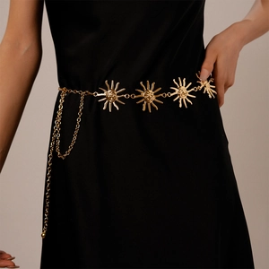 Detail view of a vintage gold metallic waist chain featuring a sun portrait medallion