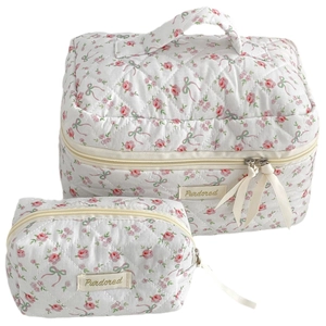 Floral quilted cosmetic bag set with pink flowers and green bow patterns on white fabric