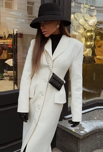 Detail view of cream white slim-fit wool coat with single-breasted buttons and flap pockets