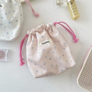 Detailed macro view of pink floral canvas drawstring bag with woven rope closure