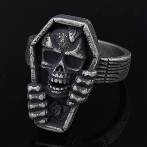 Vintage gothic skull coffin ring with rose relief and aged silver finish on black backdrop