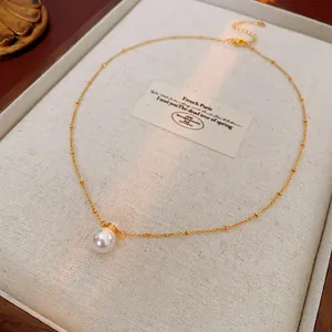 French vintage style gold pearl necklace with a large round pearl pendant on thin chain