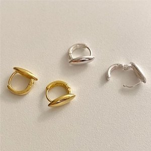 Detail of silver and gold minimalist hoop earrings with polished olive leaf studs