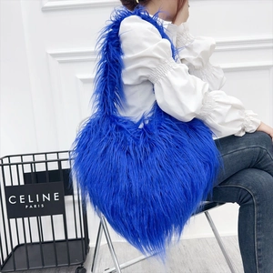 Electric blue long-pile faux fur heart bag styled with white top and denim jeans