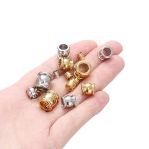 Gold and silver stainless steel spacer beads held by hand showing small size for DIY bracelets
